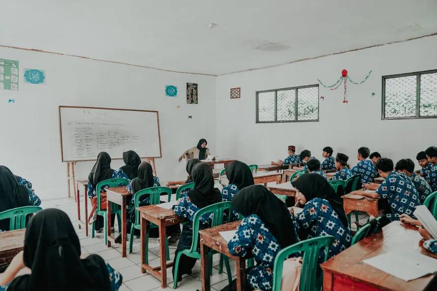 Students in traditional attire attend a lesson in a Pandeglang classroom.