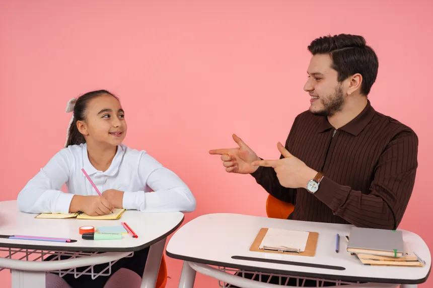 Engaging classroom scene with teacher and student sharing a conversation at school desks.